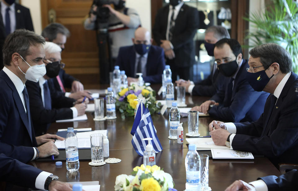 This image provided by Cyprus' press and information office shows Cyprus President Nicos Anastasiades, right, talks to Greece's Prime minister Kyriakos Mitsotakis, left during their meeting, at the presidential palace in capital Nicosia, Cyprus, Monday, Feb. 8, 2021. Mitsotakis is in Cyprus on a one day official visit. (Stavros Ioannides, PIO via AP)