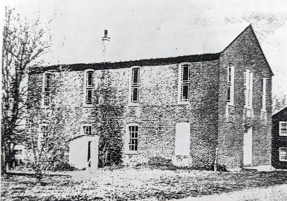 An early photo of Bethel A.M.E. Church with the stained glass intact includes an outhouse attached to the side of the building.
