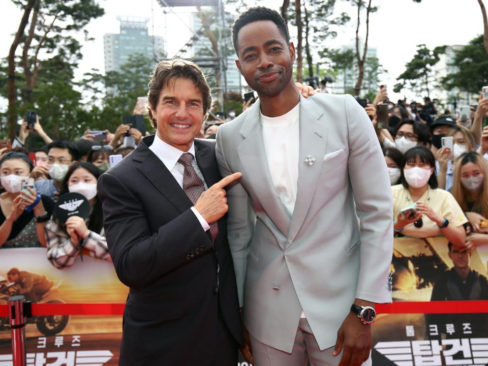 Tom Cruise with his arm around Jay Ellis and pointing at him