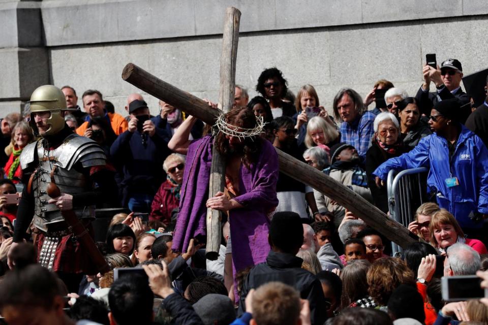 Jesus carries his cross through the crowd while wearing the crown of thorns (Reuters)