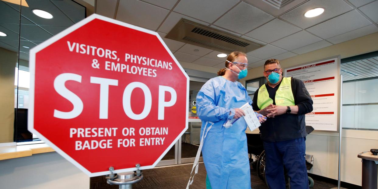 Medical personnel discuss patients that had been admitted for testing for the coronavirus at the entrance Central Maine Medical Center on Friday, March 13, 2020, in Lewiston, Maine. U.S. hospitals are setting up circus-like triage tents, calling doctors out of retirement, guarding their supplies of face masks and making plans to cancel elective surgery as they brace for an expected onslaught of coronavirus patients. (AP Photo/Robert F. Bukaty)