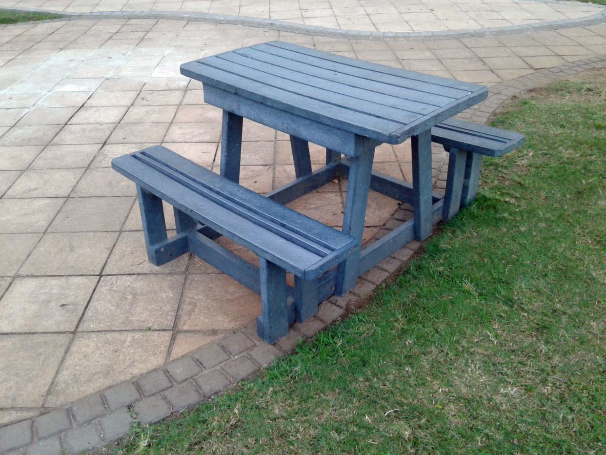 Recycled plastic used to manufacture new picnic table used beside walkway for convenience of tourists and holidaymakers