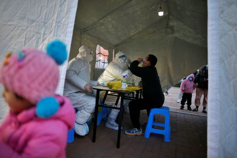 Medical worker collects a swab from a resident for nucleic acid testing at a testing site for COVID-19 in Tianjin