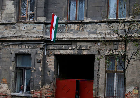 A dilapidated building shows bullet marks from the 1956 anti-Communist uprising, with the revolutionary flag posted on the front, insignia removed, in Budapest, Hungary, October 20, 2016. REUTERS/Laszlo Balogh