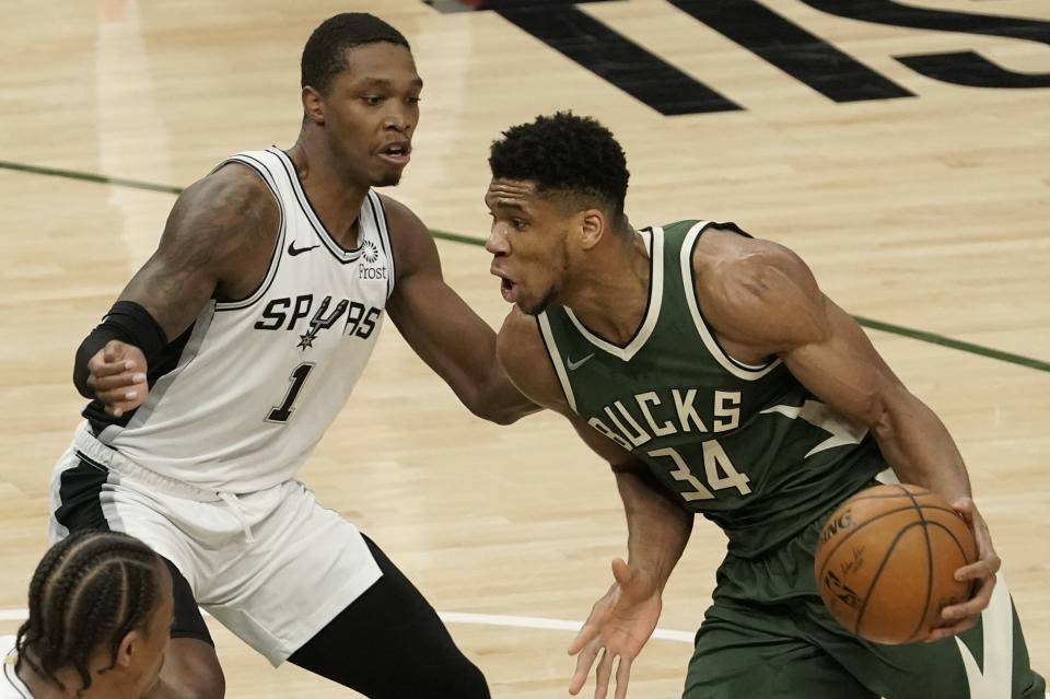 Milwaukee Bucks' Giannis Antetokounmpo tries to drive past San Antonio Spurs' Lonnie Walker IV during the first half of an NBA basketball game Saturday, March 20, 2021, in Milwaukee. (AP Photo/Morry Gash)