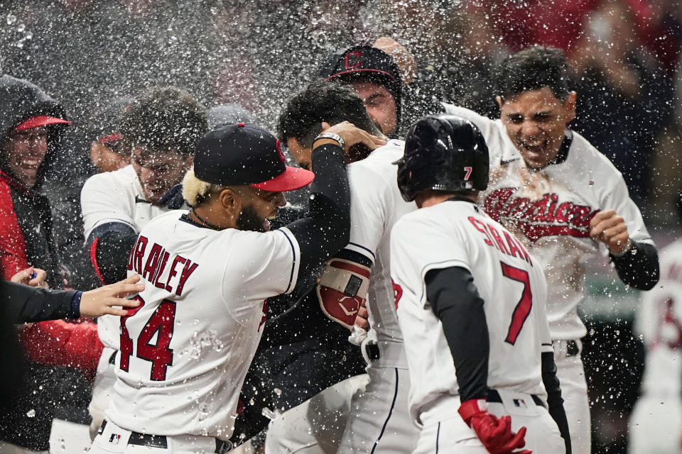 Cleveland Indians' Oscar Mercado, center, is mobbed by teammates after hitting a two-run home run in the seventh inning in the second baseball game of a doubleheader against the Chicago White Sox, Thursday, Sept. 23, 2021, in Cleveland. The Indians won 5-3. (AP Photo/Tony Dejak)