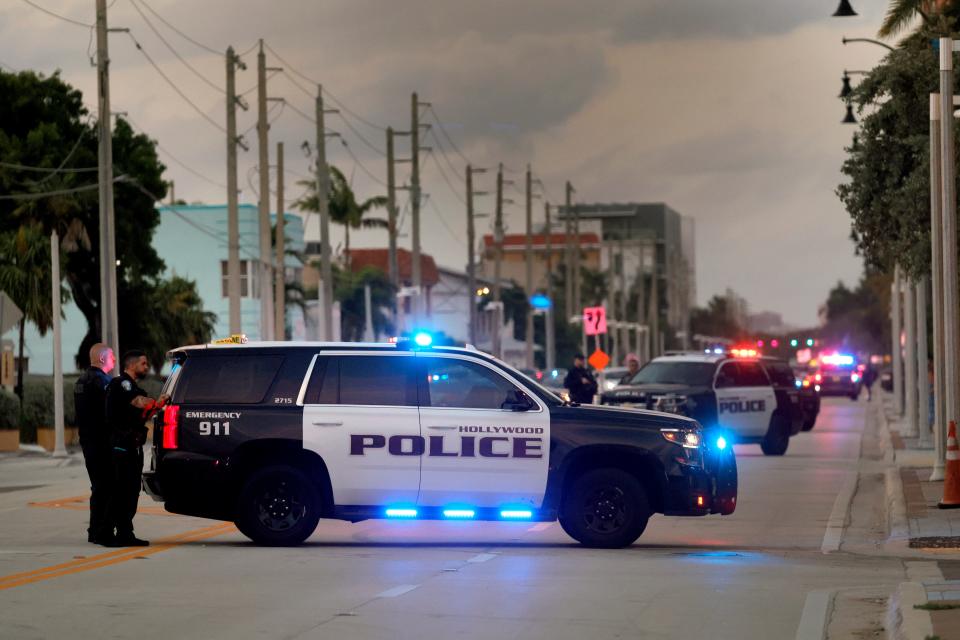 Police are pictured investigating after gunfire erupted on Memorial Day along a beach boardwalk in Hollywood, Florida, sending people frantically running for cover on Monday.