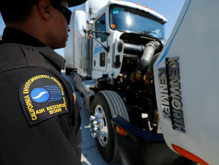 FILE PHOTO - California Air Resources field representative Jose Andujar inspects the engine of a heavy-duty truck traveling near the Mexican-U.S. border in Otay Mesa, California September 10, 2013. REUTERS/Mike Blake/File Photo