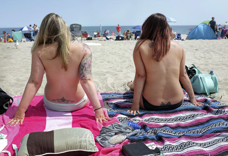 FILE - In this Aug. 26, 2017 photo, women go topless during Go Topless Day at Hampton Beach, N.H. The Supreme Court is leaving in place the public nudity convictions of three women who removed their bathing suit tops on a New Hampshire beach as part of a campaign advocating for the rights of women to go topless. The justices declined Monday to review a state court decision that found no violation of the women's constitutional rights. (Ioanna Raptis/Portsmouth Herald seacoastonline.com via AP)