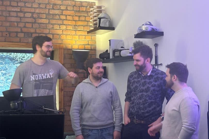 Group of men standing in their office which is based in a co-working space in Cardiff- Tramshed Tech. They run the company, Virus Tech from a small room which is part of a wider building