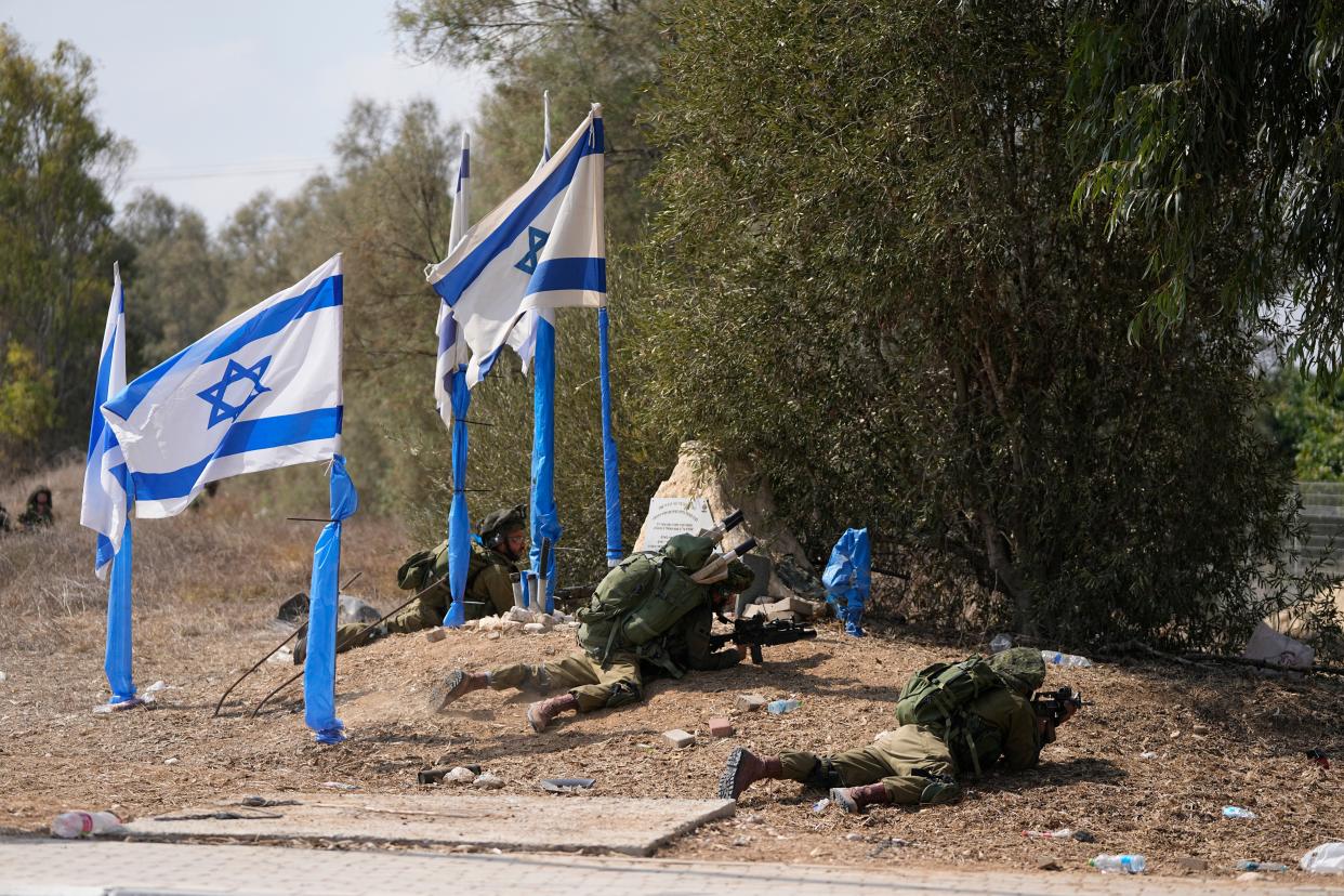 Israeli soldiers take positions in kibbutz Kfar Azza (AP)