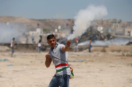 A Palestinian protester releases a firecracker during clashes with Israeli troops in the West Bank village of Beita, near Nablus May 12, 2017. REUTERS/Mohamad Torokman