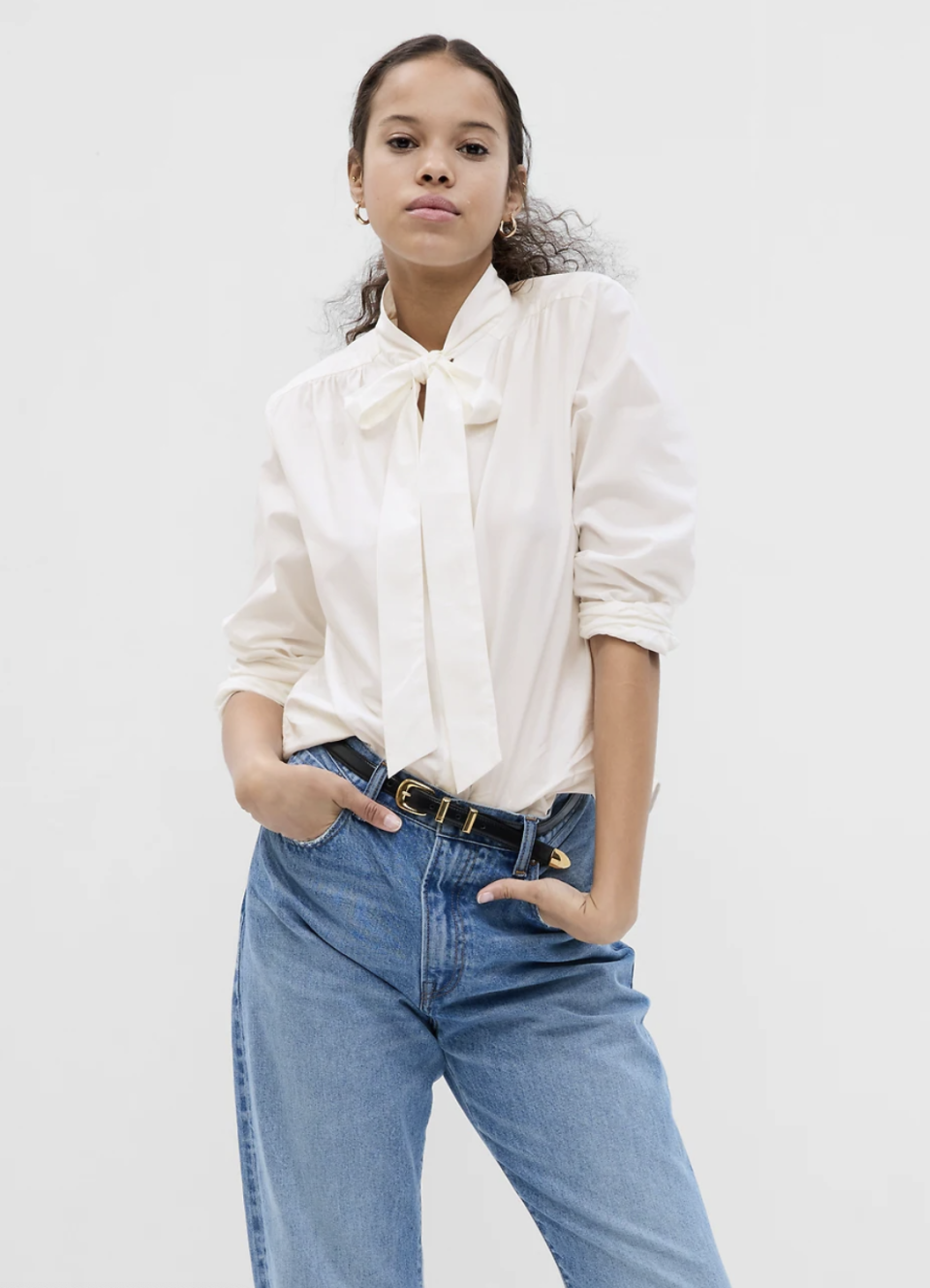 model in blue jeans and white Tie-Neck Shirt with neck bow (photo via Gap)