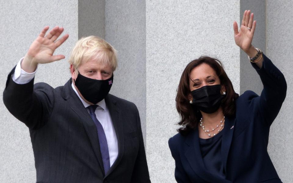 Vice President Kamala Harris and Boris Johnson wave as they tour the balcony outside the Vice President's ceremonial office at Eisenhower Executive Building - Getty