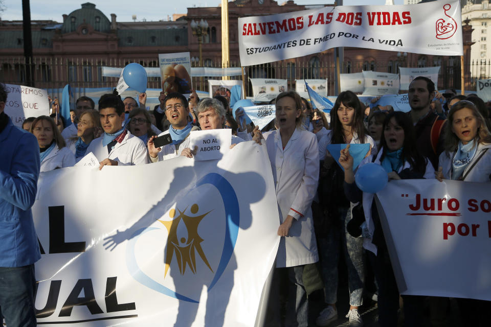 In this July 15, 2018 photo, medical doctors protest against efforts to legalize abortion, in front of Government House in Buenos Aires, Argentina. Hundreds of physicians have staged anti-abortion protests as an abortion rights bill moves toward a vote in the Senate. (AP Photo/Jorge Saenz)