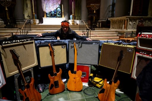 Musician and artist Laurie Anderson, Reed's widow, stands in front of his amps and guitars