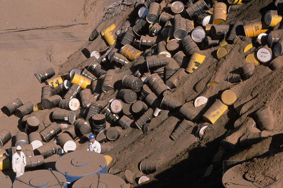 Barrels with chemicals laying on the side of a hill