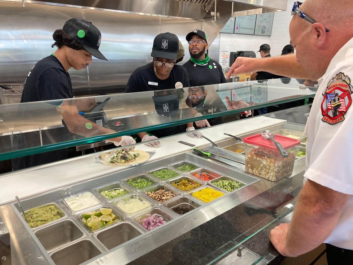 Warner Robins fire Capt. Kevin Kendrick selects toppings for a burrito at the new Surcheros Fresh Mex restaurant in Warner Robins at a friends and family event prior to the restaurant’s opening.