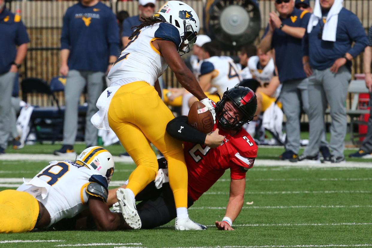 Texas Tech Red Raiders quarterback Behren Morton (2) is sacked by West Virginia Mountaineers defensive safety Aubrey Burks (2) and defensive linebacker Lee Kpogba (8) in the first half at Jones AT&T Stadium and Cody Campbell Field.