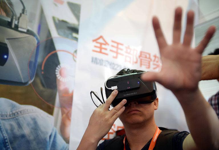 A visitor tries on virtual reality glasses from Oculus Rift Development Kit 2 during the first Consumer Electronics Show in Asia in Shanghai on May 26, 2015