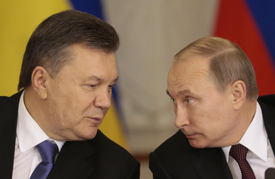 FILE - In this Tuesday Dec. 17, 2013 file photo, Russian President Vladimir Putin, right, and his Ukrainian counterpart Viktor Yanukovych talk during a news conference in Moscow. Moscow on Wednesday granted Ukrainian President Viktor Yanukovych protection "on the territory of Russia," shortly after the fugitive leader sought help from the Kremlin, according to an official quoted by Russian news agencies. (AP Photo/Ivan Sekretarev, file)