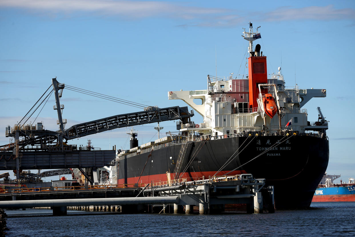 A bulk carrier docked at the Newcastle Coal Terminal as a crane unloads its cargo.