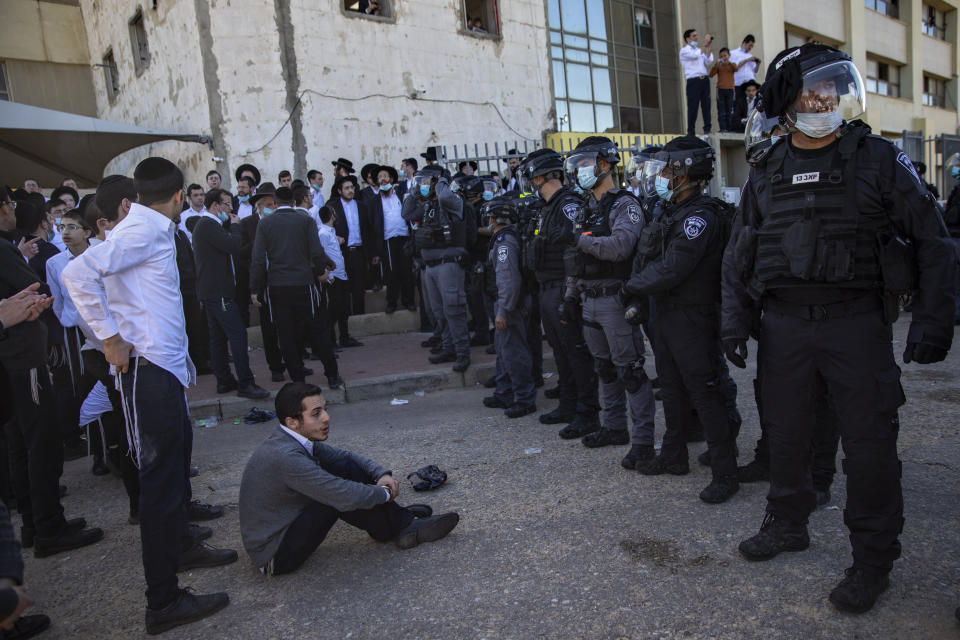 Israeli police officers clash with ultra-Orthodox Jews in Ashdod, Israel, Sunday, Jan. 24, 2021. Ultra-Orthodox demonstrators clashed with Israeli police officers dispatched to close schools in Jerusalem and Ashdod that had opened in violation of coronavirus lockdown rules, on Sunday. (AP Photo/Oded Balilty)