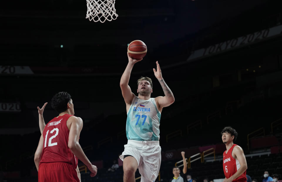 Slovenia's Luka Doncic (77) drives to the against Japan's Yuta Watanabe (12), left, during men's basketball preliminary round game at the 2020 Summer Olympics, Thursday, July 29, 2021, in Saitama, Japan. (AP Photo/Eric Gay)