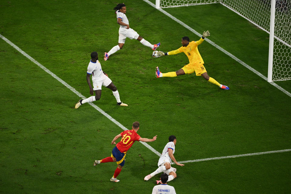 MUNICH, GERMANY - JULY 09: Dani Olmo of Spain has a shot, which is deflected by Jules Kounde of France, and results in an own goal and the second goal for Spain during the UEFA EURO 2024 Semi-Final match between Spain and France at Munich Football Arena on July 09, 2024 in Munich, Germany. (Photo by Matthias Hangst/Getty Images)