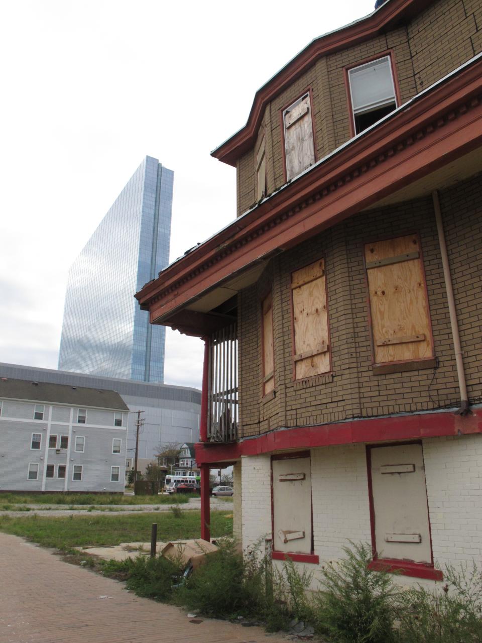 An abandoned, boarded-up house in Atlantic City N.J., sits in the shadow of the $2.4 billion Revel casino, on Sept. 19, 2012. New Jersey officials are evaluating efforts to revive the gambling resort as calls mount for them to approve casino gambling elsewhere in the state. (AP Photo/Wayne Parry)