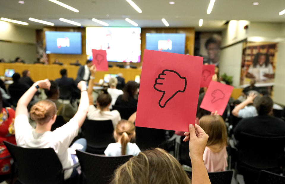 A protester holds up a "thumbs down" sign as Houston Independent School District Superintendent Mike Miles presented a slideshow to the board during the HISD board meeting at Hattie Mae White Educational Support Center on Thursday, June 22, 2023, in Houston. (Karen Warren/Houston Chronicle via AP)