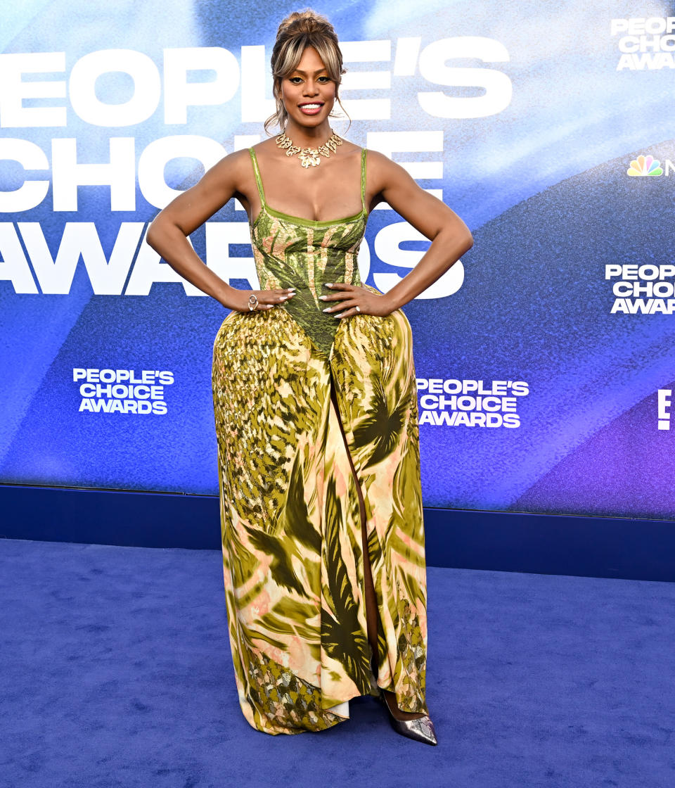 <p>Laverne Cox brings the drama to the blue carpet with her green patterned Collina Strada gown with an exaggerated silhouette at her waist. She pairs the look with gold jewelry and silver shoes for a mixed-metallic feel.</p>