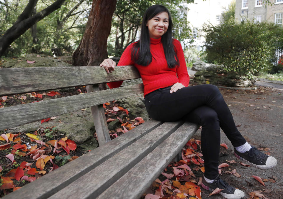 Danica Marcos, sits in a park in London, Friday, Oct. 16, 202. Danica Marcos a volunteer as U.K. researchers are preparing to begin a controversial experiment that will infect healthy volunteers with the new coronavirus to study the disease in hopes of speeding up development of a vaccine. (AP Photo/Frank Augstein)