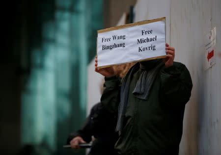 FILE PHOTO: A man holds a sign calling for China to release Wang Bingzhang and former Canadian diplomat Michael Kovrig, who was arrested in China on Tuesday, at the B.C. Supreme Court bail hearing of Huawei CFO Meng Wanzhou in Vancouver, British Columbia, Canada December 11, 2018. REUTERS/Lindsey Wasson/File Photo