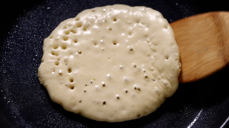 flipping a pancake on a pan
