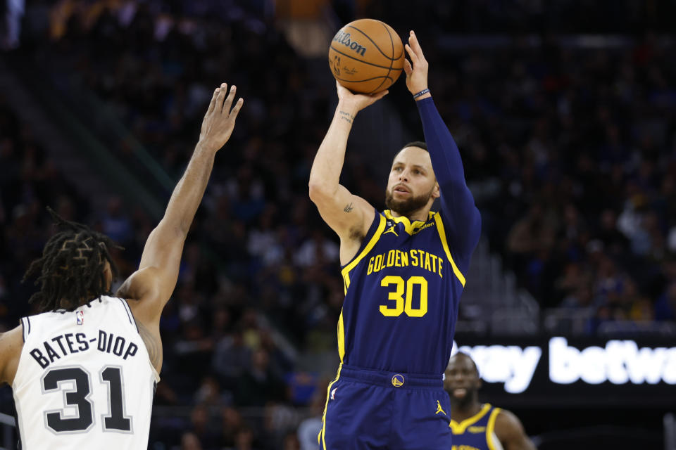 Golden State Warriors guard Stephen Curry (30) shoots against San Antonio Spurs forward Keita Bates-Diop (31) during the second half of an NBA basketball game in San Francisco, Friday, March 31, 2023. (AP Photo/Jed Jacobsohn)