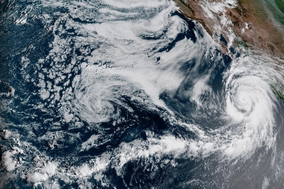 This Friday, Aug. 18, 2023, 1:10 p.m. EDT satellite image provided by the National Oceanic and Atmospheric Administration shows Hurricane Hilary, right, off Mexico's Pacific coast. Scientists figure a natural El Nino, human-caused climate change, a stubborn heat dome over the nation’s midsection and other factors cooked up Hilary’s record-breaking slosh into California and Nevada. (NOAA via AP)