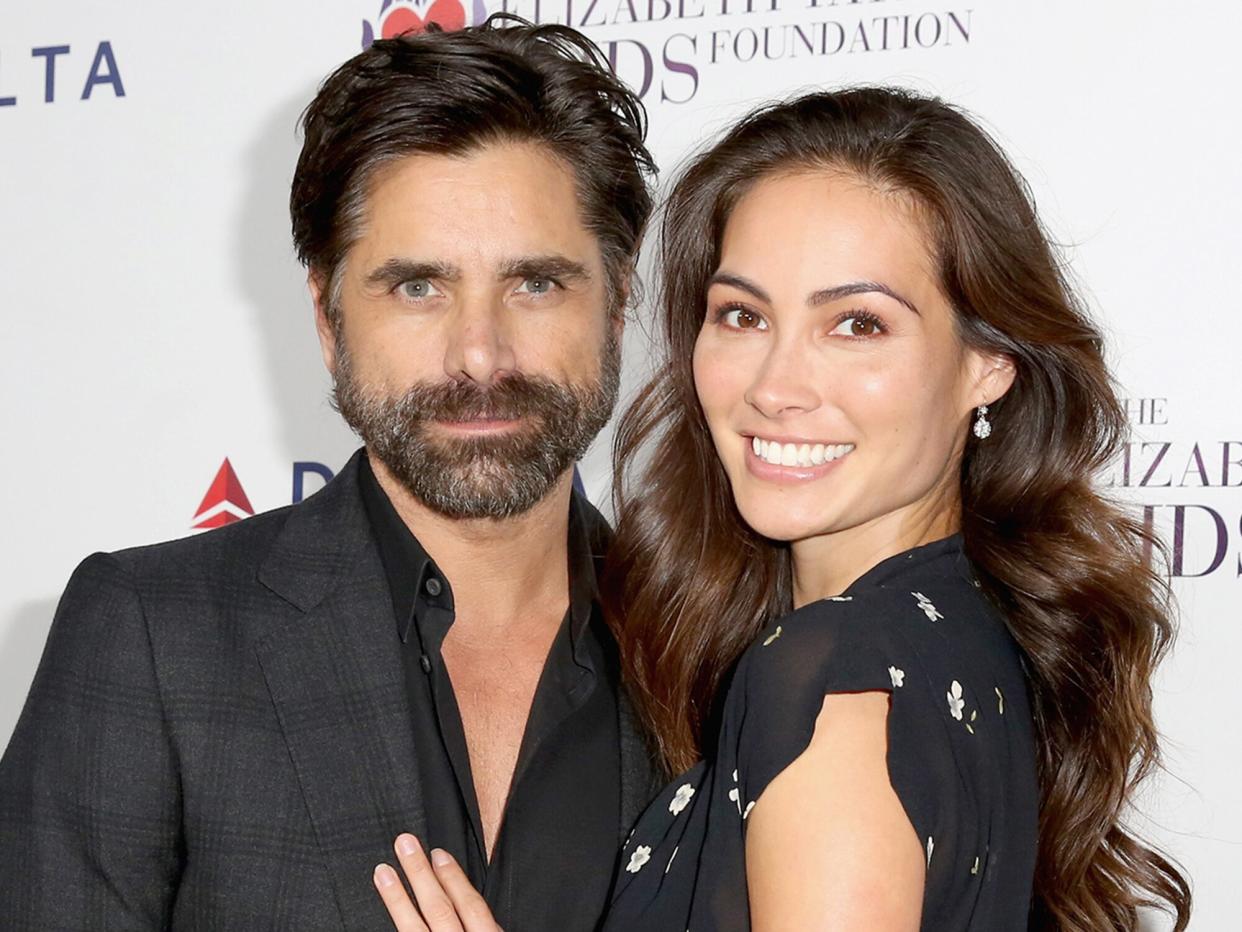 John Stamos (L) and Caitlin McHugh attend The Elizabeth Taylor AIDS Foundation and mothers2mothers dinner at Ron Burkle's Green Acres Estate on October 24, 2017 in Beverly Hills, California