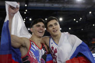 Gold medalist Nikita Nagornyy of Russia, right, and silver medalist Artur Dalaloyan of Russia celebrate with the national flag after the men's all-around final at the Gymnastics World Championships in Stuttgart, Germany, Friday, Oct. 11, 2019. (AP Photo/Matthias Schrader)