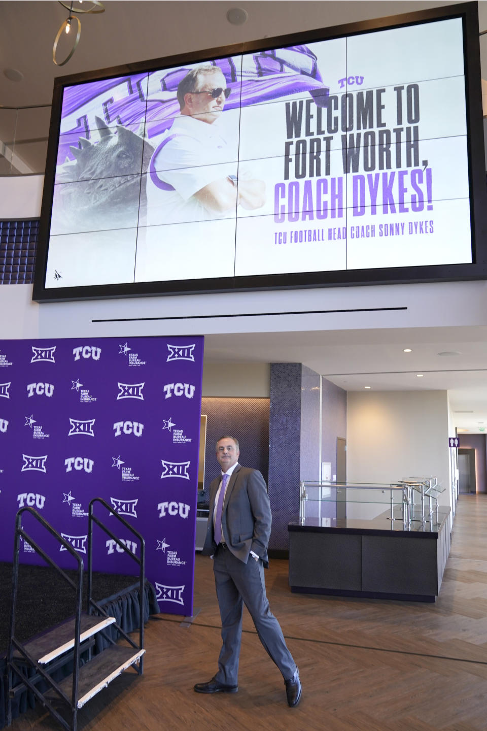 New TCU NCAA college football head coach Sonny Dykes stands under a welcome sign before an introductory news conference in Fort Worth, Texas, Tuesday, Nov. 30, 2021. (AP Photo/LM Otero)