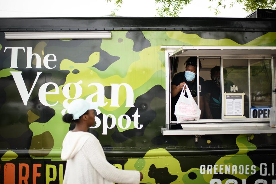 Robert Montoya hands out an order to a customer at The Vegan Spot food truck along Skibo Road on Tuesday, April 20, 2021. 