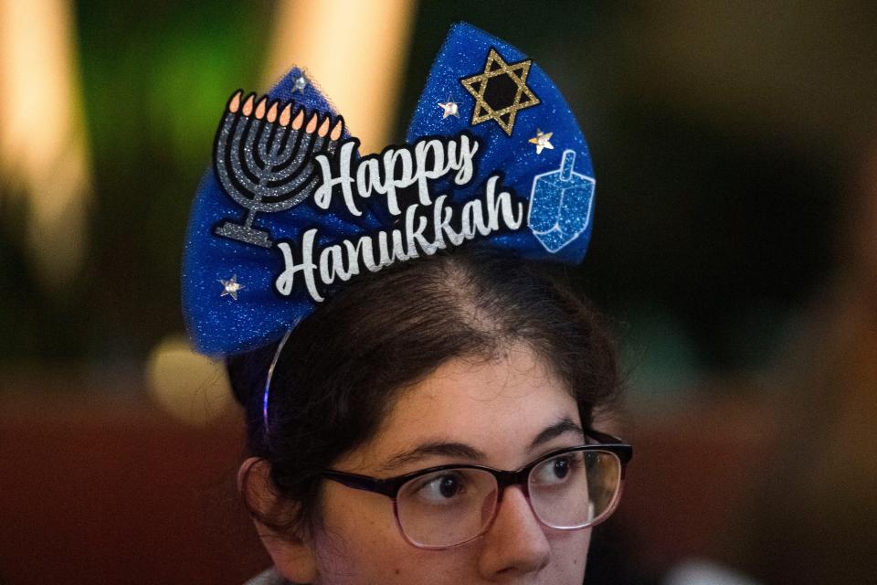 Alexis Linder wears a Happy Hanukkah headband during Chabad Jewish Center of Greenville and the Upstate's Chanukah on Main at the Hyatt Regency in Noma Square on Sunday, Dec. 10, 2023.
