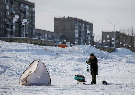 A man packs his fishing gear on frozen Irtysh River in the town of Aksu, north-eastern Kazakhstan, February 21, 2018. REUTERS/Shamil Zhumatov