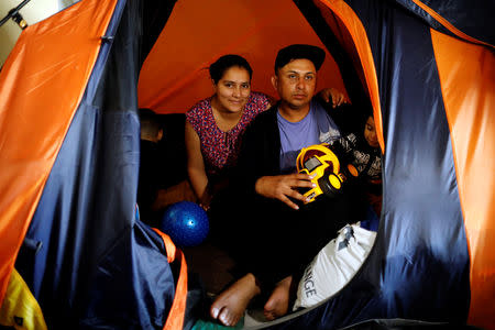 Juan Carlos Perla and his wife Ruth Aracely pose for a photograph inside the shelter in Tijuana, Mexico April 6, 2019. Picture taken April 6, 2019. REUTERS/Carlos Jasso