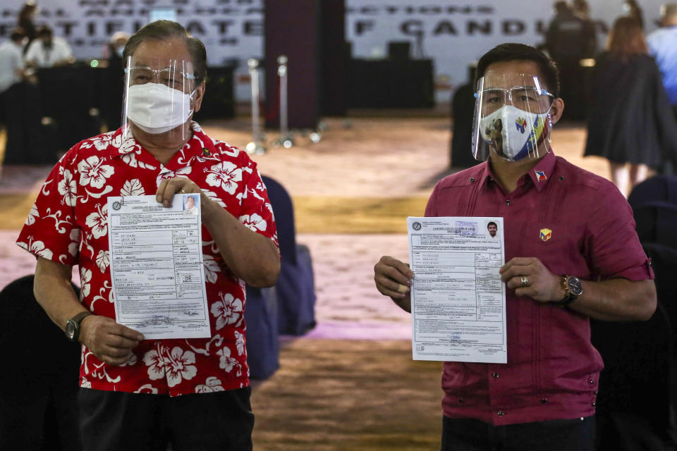 Presidential hopeful retired Filipino boxing star Manny Pacquiao, right, and running mate former Manila mayor Lito Atienza show their certificate of candidacy for next year's elections after filing it before the Commission on Elections at the Sofitel Harbor Garden Tent in Manila, Philippines on Friday, Oct. 1, 2021. Friday marks the start of a weeklong registration period for candidates seeking to lead a Southeast Asian nation that has been hit hard by the pandemic and deep political conflicts.(Jam Sta Rosa/Pool Photo via AP)