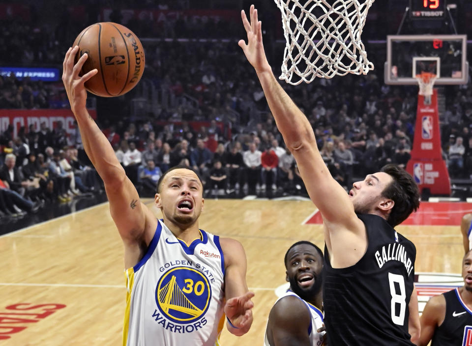 Golden State Warriors guard Stephen Curry, left, shoots as Los Angeles Clippers forward Danilo Gallinari defends during the first half of an NBA basketball game Friday, Jan. 18, 2019, in Los Angeles. (AP Photo/Mark J. Terrill)