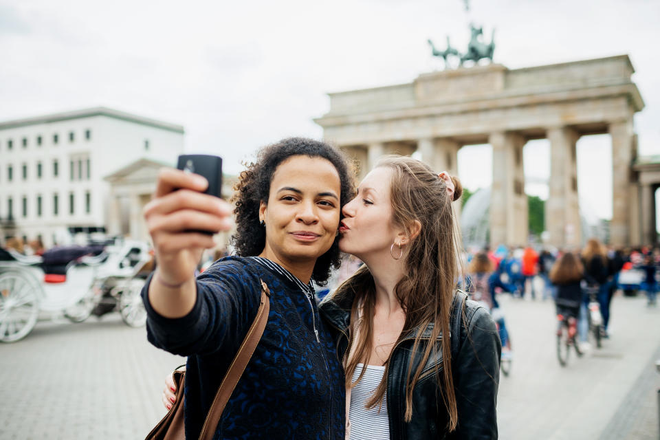 Young lesbian Couple Stop To Take A Selfie At Brandenburg Gate in Berlin (Hinterhaus Productions / Getty Images)