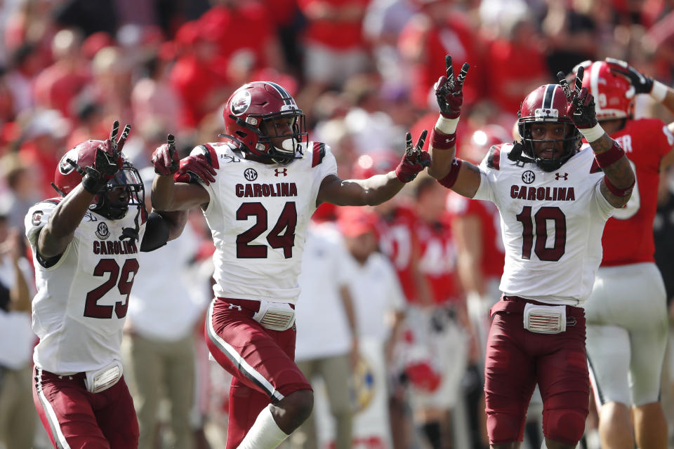 South Carolina defensive backs Israel Mukuamu (24) celebrates with J.T. Ibe (29) and R.J. Roderick (10) after intercepting a pass in the second half of an NCAA college football game against Georgia, Saturday, Oct. 12, 2019, in Athens, Ga. South Carolina won 20-17 in double overtime. (AP Photo/John Bazemore)