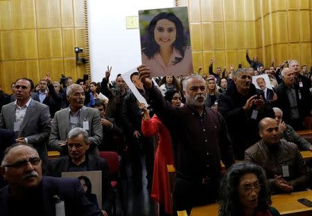 A supporter holds a portrait of Figen Yuksekdag, detained co-leader of Turkey's pro-Kurdish opposition Peoples' Democratic Party (HDP) at a meeting at the Turkish parliament in Ankara, Turkey, November 8, 2016, in the absence of Yuksekdag and other HDP lawmakers who were jailed after refusing to give testimony in a probe linked to "terrorist propaganda". REUTERS/Umit Bektas/File Photo