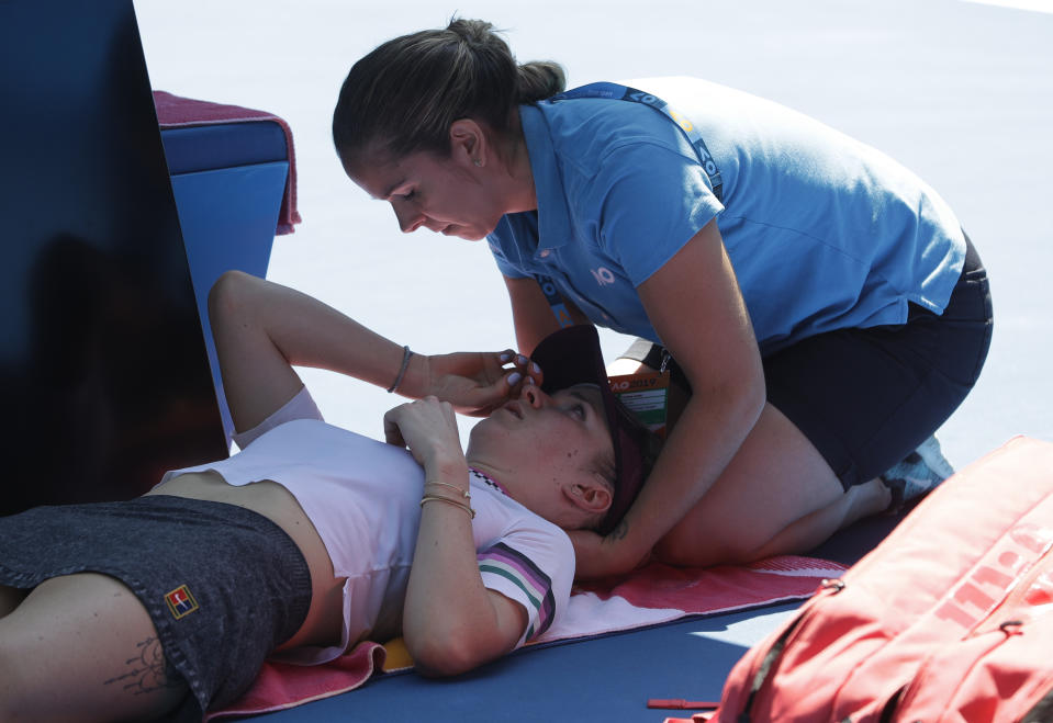 Ukraine's Elina Svitolina receives treatment from a trainer during her quarterfinal against Japan's Naomi Osaka at the Australian Open tennis championships in Melbourne, Australia, Wednesday, Jan. 23, 2019. (AP Photo/Mark Schiefelbein)